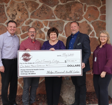 PMHC representatives and CCC representatives stand with a big check for grant donation