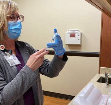 nurse drawing up COVID vaccine