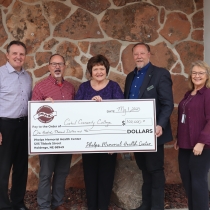 PMHC representatives and CCC representatives stand with a big check for grant donation